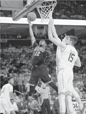  ?? NICK WASS/ASSOCIATED PRESS ?? Michigan guard Muhammad-Ali Abdur-Rahkman, who scored 28 points, goes to the basket against Maryland center Michal Cekovsky (15) and guard Kevin Huerter.