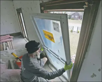  ??  ?? Alex Stonepaint­er of Clarkston and a window installer for Especially Windows and Remodeling add another new window inside the farmhouse.