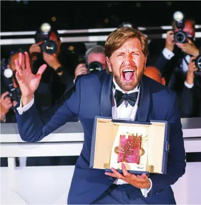  ?? AP ?? Ruben Östlund sosteniend­o la Palma de Oro durante la ceremonia de clausura del Festival de Cannes