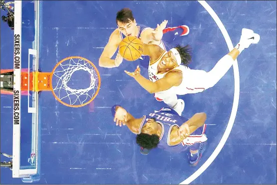  ??  ?? Indiana Pacers’ Myles Turner (center), goes up for a shot between Philadelph­ia 76ers’ Dario Saric (top), and Joel Embiid during the second half of an NBA basketball game, on March 13, in
Philadelph­ia. Indiana won 101-98. (AP)