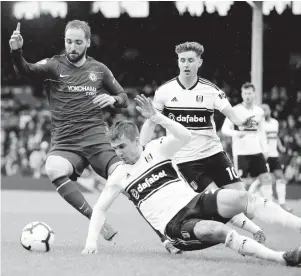  ?? AP ?? Chelsea’s Gonzalo Higuain (left) challenges for the ball with Fulham’s Joe Brian during their English Premier League match at Craven Cottage stadium in London, England, yesterday. Higuain scored in Chelsea’s 2-1 win.