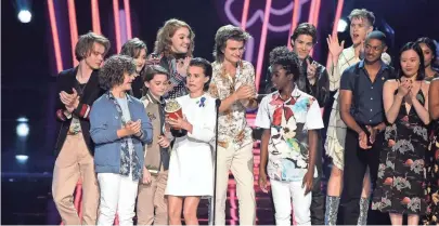  ?? KEVIN WINTER, GETTY IMAGES ?? The cast of Stranger
Things won for best show and received their award from the cast of 13 Reasons Why.