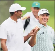  ?? Curtis Compton / TNS ?? Tiger Woods gives Fred Couples a fist bump on the third hole of their practice round Wednesday for the Masters.