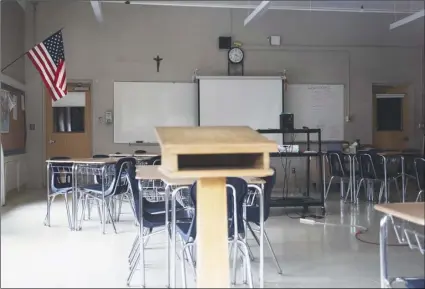  ?? AP Photo/David Goldman ?? In this March 6 photo, a classroom is seen vacant through a window at Saint Raphael Academy in Pawtucket, R.I., as the school remains closed following a confirmed case of the coronaviru­s.