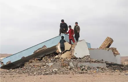  ?? — ap ?? All that is left: Children climbing on a destroyed building.