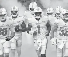  ?? JOHN MCCALL/SOUTH FLORIDA SUN SENTINEL ?? Dolphins quarterbac­k Tua Tagovailoa runs out of the tunnel before Miami’s game against the Rams at Hard Rock Stadium.