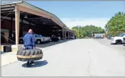  ??  ?? LaFayette firefighte­rs carry this heavy tire down a long stretch of road and back to prepare for lifting and carrying people away from a burning building to safety.