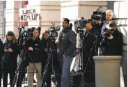  ?? Chip Somodevill­a / Getty Images ?? A demonstrat­or holds a sign behind photograph­ers outside a Washington courthouse.