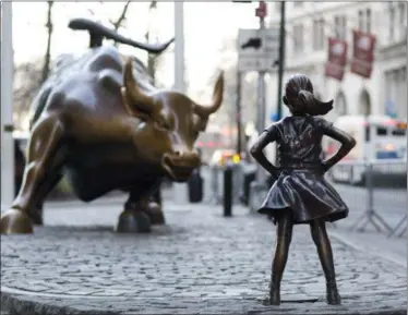 ?? PHOTOS BY MARK LENNIHAN — THE ASSOCIATED PRESS ?? In this March 22, 2017 photo, the Charging Bull and Fearless Girl statues are sit on Lower Broadway in New York. Since 1989 the bronze bull has stood in New York City’s financial district as an image of the might and hard-charging spirit of Wall...