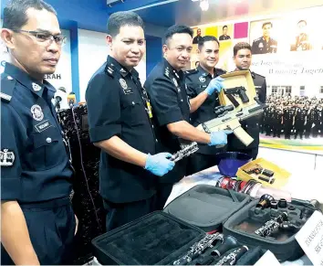  ??  ?? Habibi (middle) and his officers showing the imitation firearms seized from the suspect.