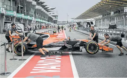  ?? AFP ?? Boxes. Uno de los McLaren entra a su sector en el primer día de trabajo de la última carrera malaya.