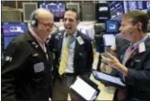  ?? RICHARD DREW — THE ASSOCIATED PRESS ?? Traders Andrew Silverman, left, Gregory Rowe, center, and Robert Charmak share a laugh as they work on the floor of the New York Stock Exchange, Friday. Stocks hardly budged Friday as the U.S. and Canada were unable to complete a trade deal, but the two sides intend to continue negotiatin­g next week.