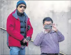  ?? CP PHOTO ?? A man takes a photograph with a smartphone while waiting in line to enter a courtroom to attend a bail hearing for Meng Wanzhou, the chief financial officer of Huawei Technologi­es, at B.C. Supreme Court in Vancouver, on Friday.