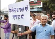 ?? PTI ?? Delhi Transport Minister Kailash Gahlot displays a placard asking people to obey the odd-even rule at ITO in New Delhi on Monday