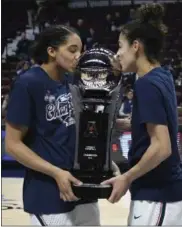  ?? THE ASSOCIATED PRESS FILE ?? Connecticu­t’s Gabby Williams and Kia Nurse, right, kiss the American Athletic Conference championsh­ip trophy after defeating South Florida in the final of the conference’s tournament, in Uncasville, Conn.