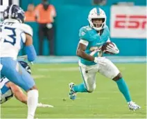  ?? JOHN MCCALL/SOUTH FLORIDA SUN SENTINEL ?? Dolphins running back De’Von Achane runs with the ball against the Titans during the first half at Hard Rock Stadium on Monday in Miami Gardens.