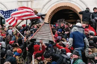  ?? Lev Radin/Tribune News Service ?? Insurrecti­onists clashing with police use a ladder to try to force entry into the Capitol. A Universal City man was sentenced to seven years in prison for assaulting an officer during the riot.