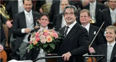  ??  ?? Sul podio Il maestro Riccardo Muti (76 anni) con il mazzo di fiori ricevuti per aver diretto, per la quinta volta dal 1993, il tradiziona­le concerto di Capodanno di Vienna