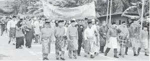  ??  ?? (Gambar atas) BUNG MOKTAR bersama pemimpin masyarakat berarak dari Padang MDK ke Dewan Sri Lamag. (Gambar kanan) YASSIN menyampaik­an cendera kenangan kepada Bung Moktar.