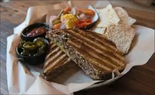  ?? Christian Snyder/ Post- Gazette ?? A steak and cheddar cheese sandwich from Lincoln Avenue Brewery is served with candied jalepeno peppers, red sauce, tortilla chips and pickled vegetables.