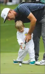  ?? The Associated Press ?? Kevin Chappell helps his son Wyatt putt on the second hole during the Par 3 competitio­n at the Masters golf tournament on Wednesday in Augusta, Ga.