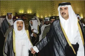  ?? KUWAIT NEWS AGENCY ?? Kuwait’s Emir Sheikh Sabah Al Ahmad Al Sabah (left) holds the hand of Qatar’s Emir Sheikh Tamim bin Hamad Al Thani in Doha, Qatar, on June 7. Bahrain, Egypt, Saudi Arabia and the United Arab Emirates cut economic, diplomatic and travel ties with Qatar...