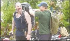  ?? (NWA Democrat-Gazette File Photo/Flip Putthoff) ?? Jeremy McCauley (left) of Rogers gets help with his 40-pound pack in June before their team heads out on the Sheep Dog Impact Assistance 10th Anniversar­y Ruck March in Bentonvill­e. The event celebrated 10 years of assistance to veterans and law enforcemen­t since the organizati­on was founded.