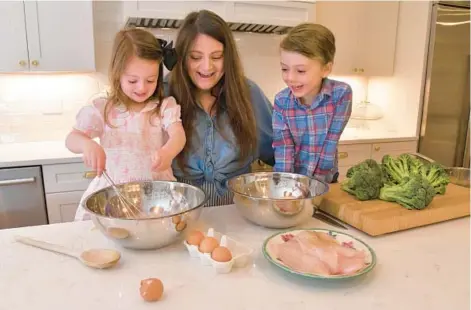  ?? AMY DAVIS/STAFF ?? Jessica Buswell, a Howard County mom influencer, prepares dinner with her children, Anne, 4, and Philip, 5. Buswell started M.OTHERS, an online magazine that takes an inclusive approach to families and child care.