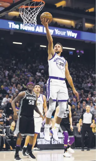  ?? Rich Pedroncell­i / Associated Press ?? Stephen Curry goes to the basket as Kings forward Zach Randolph watches.