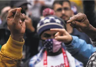  ?? David Goldman / Associated Press ?? Supporters of Biden and Trump gesture as they argue over the election results outside the central counting board at the TCF Center in Detroit on Thursday.