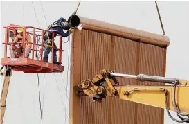  ?? Gregory Bull / Associated Press ?? Crews work this week on a border wall prototype near the border with Tijuana. Companies are nearing Thursday’s deadline to finish building eight prototypes of President Donald Trump’s proposed wall.