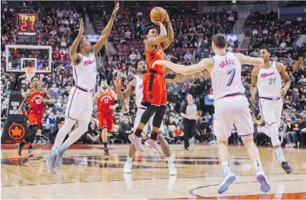  ?? MARK BLINCH/THE CANADIAN PRESS ?? Toronto Raptors guard Kyle Lowry puts up a shot against Miami Heat players, from left, Josh Richardson, Goran Dragic and Hassan Whiteside on Tuesday in a 115-112 Toronto victory that saw Lowry score 22 points and fellow NBA all-star DeMar DeRozan score...