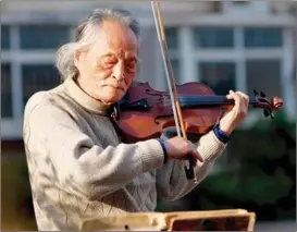  ?? XINHUA ?? Wang Xin plays the violin at home in March.