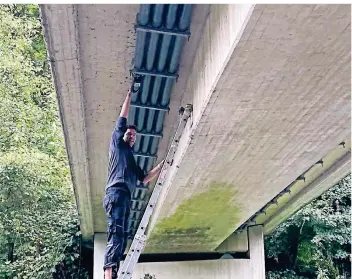  ?? FOTO: PASCH ?? IHK-Präsident Henner Pasch befestigt einen Sensor unter der Brücke Rüdenstein auf Solinger Gebiet.