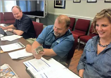  ?? Doug Walker / Rome News-Tribune ?? Floyd County Manager Jamie McCord (from left) watches as Rome-Floyd County ECO Center Director Ben Winkelman tries to get Keep Rome Floyd Beautiful Director Mary Hardin Thornton to take a baby opossum.