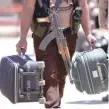  ?? — Reuters ?? A rebel fighter carries suitcases and his weapon prior to boarding a bus as fighters and their families evacuate the besieged Al Waer district.