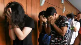  ??  ?? YOUNG AND BUSTED The arrested drug suspects cover their faces at the NBI media briefing on Wednesday. The bureau alleged that they operated a drug laboratory in Parañaque City, as shown by the alleged samples seized from the group.