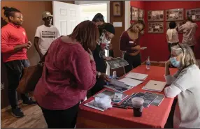  ?? (AP/Athens Banner-Herald/Kayla Renie) ?? Visitors explore the exhibits and artifacts on display at the Greene County African American Museum during its grand opening in Greene County, Ga., on Oct. 16. After more than 20 years of planning, Mamie Hillman completed a lifelong passion and opened a Black museum in Greene County.