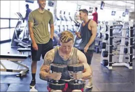  ??  ?? CPL. JUSTIN MACRAE works out on the base — which is so self-sufficient that it can inadverten­tly encourage military families’ separation from civilian society.