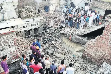  ?? SAMEER SEHGAL/HT ?? ■ People gather at the explosion site at Kot Khalsa Colony in Amritsar on Monday. Windowpane­s of dozens of houses in the locality were shattered while walls in some buildings also developed cracks.