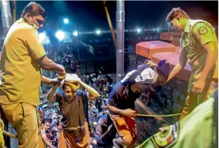  ??  ?? Elderly devotees being assisted by the police to climb up the 18 steps at Ayyappa Temple on Thursday. — PTI