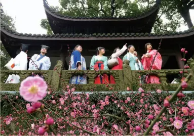  ??  ?? 汉服爱好者们在浙江杭­州市孤山景区放鹤亭上­观赏梅花