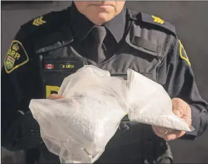  ??  ?? An OPP officer displays bags containing fentanyl following a major seizure last month.