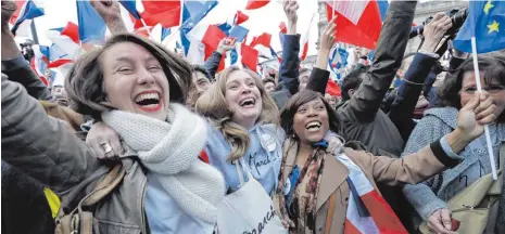  ?? FOTO: AFP ?? Feiernde Anhänger von Emmanuel Macron in Paris: Der 39-Jährige versprach, ein neues Kapitel in der Geschichte Frankreich­s aufzuschla­gen.