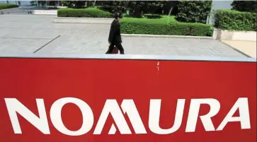  ?? — Reuters ?? Growth strategy: A Nomura logo is seen in Tokyo. The firm has been gradually diversifyi­ng away from stock broking for retail clients and other market-dependent business toward services that generate more stable fees.
