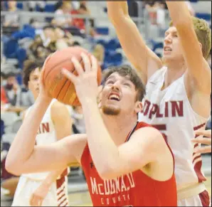  ?? RICK PECK/ SPECIAL TO MCDONALD COUNTY PRESS ?? McDonald County’s Teddy Reedybacon is guarded by Joplin’s Micah Bruggeman on Nov. 24 at Joplin High School.