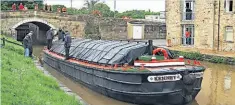  ?? ?? Leeds & Liverpool ‘short boat’ Kennet is the first through the lock, watched by members of the reconstruc­tion team and nearby residents.