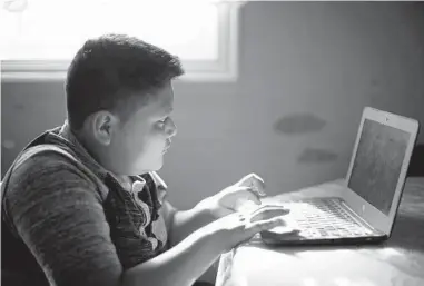  ?? COURTNEY HERGESHEIM­ER/COLUMBUS DISPATCH ?? Carlos Silva Gomez, 11, who is from Guatemala, does some homework at his home in Columbus, Ohio.