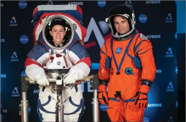  ?? (AP file photo) ?? In a 2019 unveiling of spacesuit prototypes at NASA headquarte­rs in Washington, spacesuit engineer Kristine Davis (left) wears the Exploratio­n Extravehic­ular Mobility Unit, or xEMU, designed for exploring the surface of the moon’s South Pole. Orion Crew Survival project manager Dustin Gohmert displays the suit that would be used for launch and reentry aboard the Orion spacecraft.