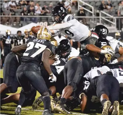  ?? AP ?? Quarterbac­k Desmond Ridder leaps over UCF’s defensive line for a one- yard TD in the second half of No. 7 Cincinnati’s victory.